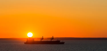 Dry Cargo Vessel At Anchor When It Sunset.